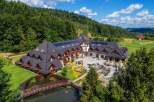 an aerial view of a large house with a roof at Hotel & SPA Czarny Groń in Rzyki