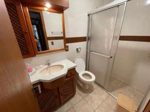 ein Badezimmer mit Toilette, Waschbecken und Dusche in der Unterkunft Apartamento a uma quadra da praia in Capão da Canoa