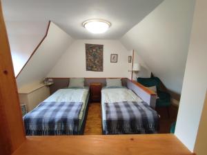 um quarto no sótão com 2 camas e um candeeiro em Stodola Svatý Štěpán em Bylnice