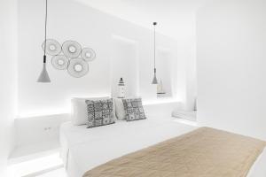 een witte slaapkamer met een bed met witte muren bij August Mykonos in Mykonos-stad