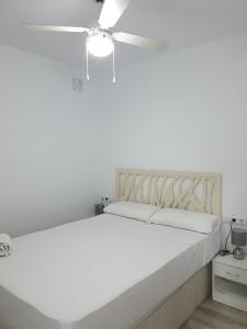 1 dormitorio con 1 cama blanca y ventilador de techo en Style Apartments Cabanyal Marina Beach, en Valencia