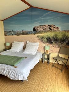 Schlafzimmer mit einem großen Bett und Blick auf die Wüste in der Unterkunft Campiotel Les Dunes - ROMANEE in Ars-en-Ré