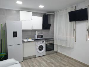 cocina con armarios blancos y lavadora en Style Apartments Cabanyal Marina Beach, en Valencia