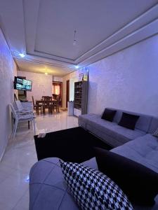 uma sala de estar com um sofá e uma sala de jantar em Appartement Aéroport Casablanca em Dah Hammou Ben Cheïkh