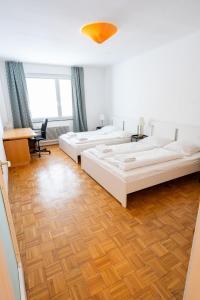 a bedroom with two beds and a desk and a table at Central Living Apartments - Staatsoper in Vienna