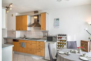a kitchen with wooden cabinets and a table and a microwave at Haus Zum Rochusberg 1 in Bingen am Rhein +9 photos