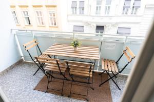 a wooden table and two chairs on a balcony at Central Living Apartment Opera in Vienna
