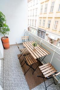 a wooden table and chairs on a balcony at Central Living Apartment Opera in Vienna