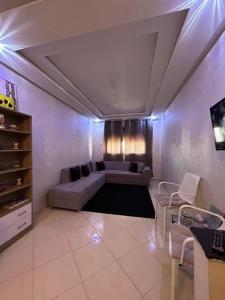 ein Wohnzimmer mit einem Sofa und einem TV in der Unterkunft Appartement Aéroport Casablanca in Dah Hammou Ben Cheïkh