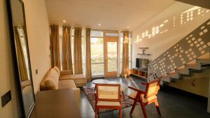 a living room with a couch and a table at Bir Valley Retreat in Bīr