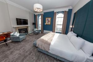 ein Schlafzimmer mit einem großen Bett und einem Kamin in der Unterkunft Commodore Hotel in Cobh