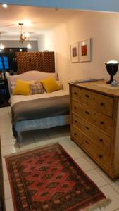 a bedroom with a bed with a dresser and a rug at Daiches Braes Brunstane Portobello in Edinburgh