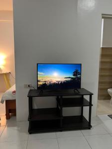 a flat screen tv sitting on a table in a room at Reinhardshausen Suites and Residences- Lovely Air-Conditioned Units in Tuguegarao City