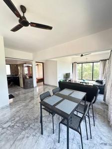 a living room with a ceiling fan and a table and chairs at Granthika’s House in Harnai