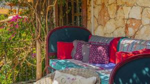 a bench with colorful pillows sitting on a porch at Fidanka Hotel in Kalkan