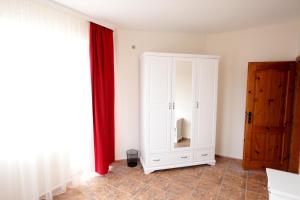 a white cabinet in a room with a red curtain at Villa Musica in Balchik +14 photos
