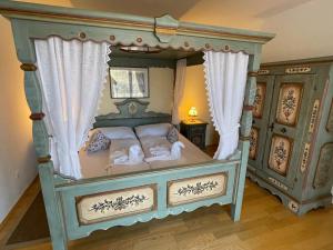 a bedroom with a canopy bed with curtains at Rosenhof am See Ferienwohnung Enzian in Thiersee