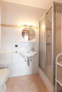 a bathroom with a sink and a shower and a toilet at Landgasthof Postwirt in Lam