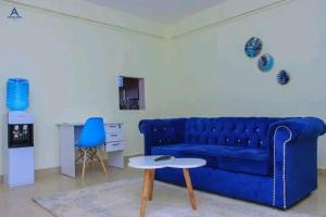 a living room with a blue couch and a table at Arctic kerugoya in Keruguya