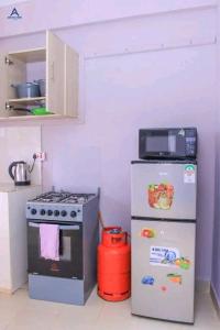 a small kitchen with a stove and a refrigerator at Arctic kerugoya in Keruguya