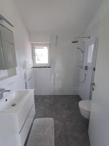 a white bathroom with a sink and a toilet at Ferienwohnung Maria & Luis in Kolsass +73 photos