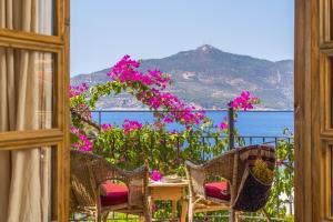 a balcony with a table and chairs and pink flowers at Fidanka Hotel in Kalkan