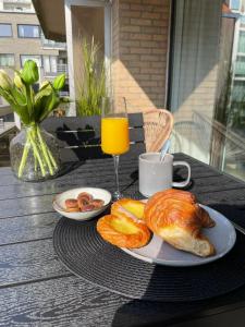 a table with two plates of food and a glass of orange juice at Studio-be in Nieuwpoort