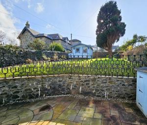 a stone fence in front of a house at Merchant's View - Luxury Seaside Designer Retreat in Rothesay