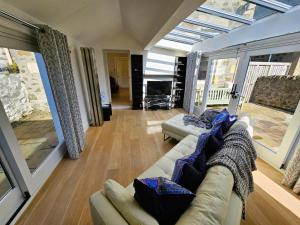 sala de estar con sofá y ventana grande en Merchant's View - Luxury Seaside Designer Retreat en Rothesay