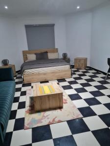 a bedroom with a bed and a checkered floor at ARABESK in Nouakchott