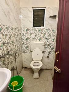 a bathroom with a toilet and a sink at The Lakeview Apart-Hotel in Agartala