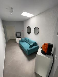 un salon avec un canapé bleu et une télévision dans l'établissement Rooms, à Bacău