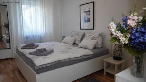 a bed in a bedroom with a vase of flowers at Apartments Marja in Njivice