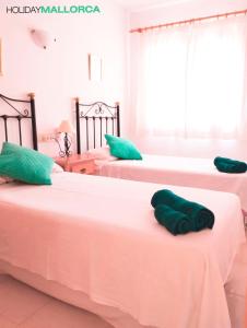 Dos camas en una habitación con toallas verdes. en Beach Plaza Mal Pas, en Cielo de Bonaire 