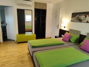 two beds in a room with green and pink at Hotel Stock Bäckerstüble in Friedrichshafen