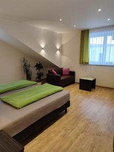 ein Schlafzimmer mit einem großen Bett und einem Sofa in der Unterkunft Hotel Gästehaus Stock Zimmer Bäckerstüble in Friedrichshafen