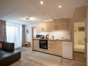 uma cozinha com armários de madeira e um forno com placa de fogão em Rosenhof am See em Thiersee
