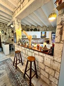una cucina con due sgabelli e un bancone in una stanza di Alaçatı Kavalalı Otel ad Alaçatı
