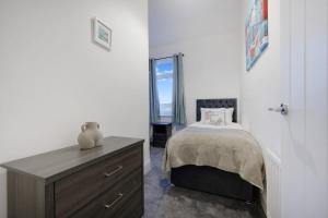 a bedroom with a bed and a dresser and a window at Newly refurbished Near the coast Sleeps 5 in Newbiggin-by-the-Sea