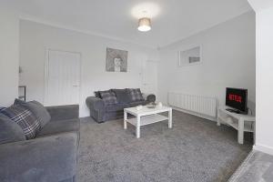a living room with a couch and a tv at Modern Apartment Near Blyth Coast Sleeps 5 in Blythe