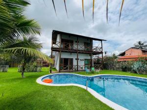 uma villa com piscina em frente a uma casa em Cond. duplo novo com piscina a 10mt da praia em Barra Grande