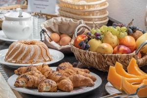 una mesa con platos de comida y cestas de fruta en Messner Palace, en Venecia