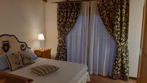 a bedroom with a bed with curtains and a window at Casa Logos Stintino Country Paradise in Stintino