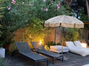 a patio with two chairs and an umbrella at La Vagabonde in Saint-Tropez