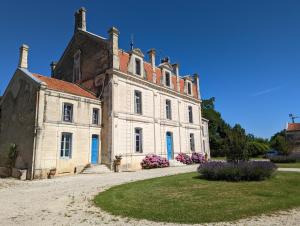 un antiguo edificio de piedra con puertas azules y flores en Domaine du Faure en Chadurie