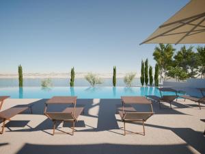 a group of chairs and an umbrella next to a pool at Mobile homes at Aminess Avalona Resort, Island Pag in Povljana