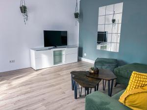 ein Wohnzimmer mit einem Sofa, einem TV und einem Tisch in der Unterkunft Gemütliches Apartment in zentraler Lage in Hamburg Alsterdorf für bis zu 7 Personen in Hamburg
