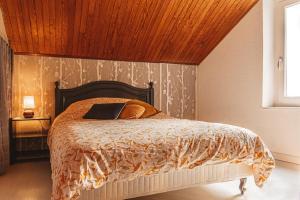 una camera con letto e soffitto in legno di Maison place de la Pieta a Chirac