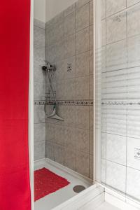 a shower with a red curtain and a red shower rug at Maison place de la Pieta in Chirac