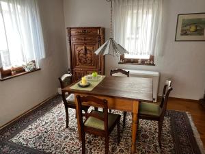 uma sala de jantar com uma mesa de madeira e cadeiras em Torbogenhäuschen im Herzen von Ruit em Ostfildern